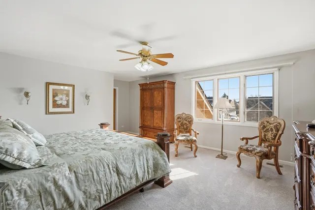 a spacious bedroom with a bed a table and chair
