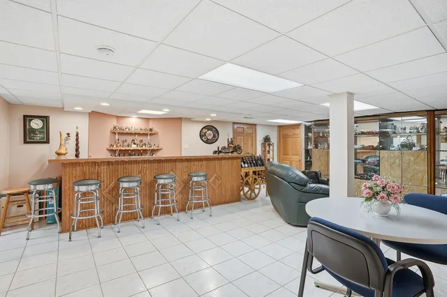 a kitchen with furniture a stove a sink a dining table and chairs