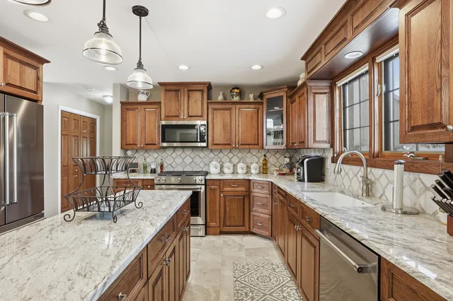 a kitchen with stainless steel appliances granite countertop a sink stove and refrigerator