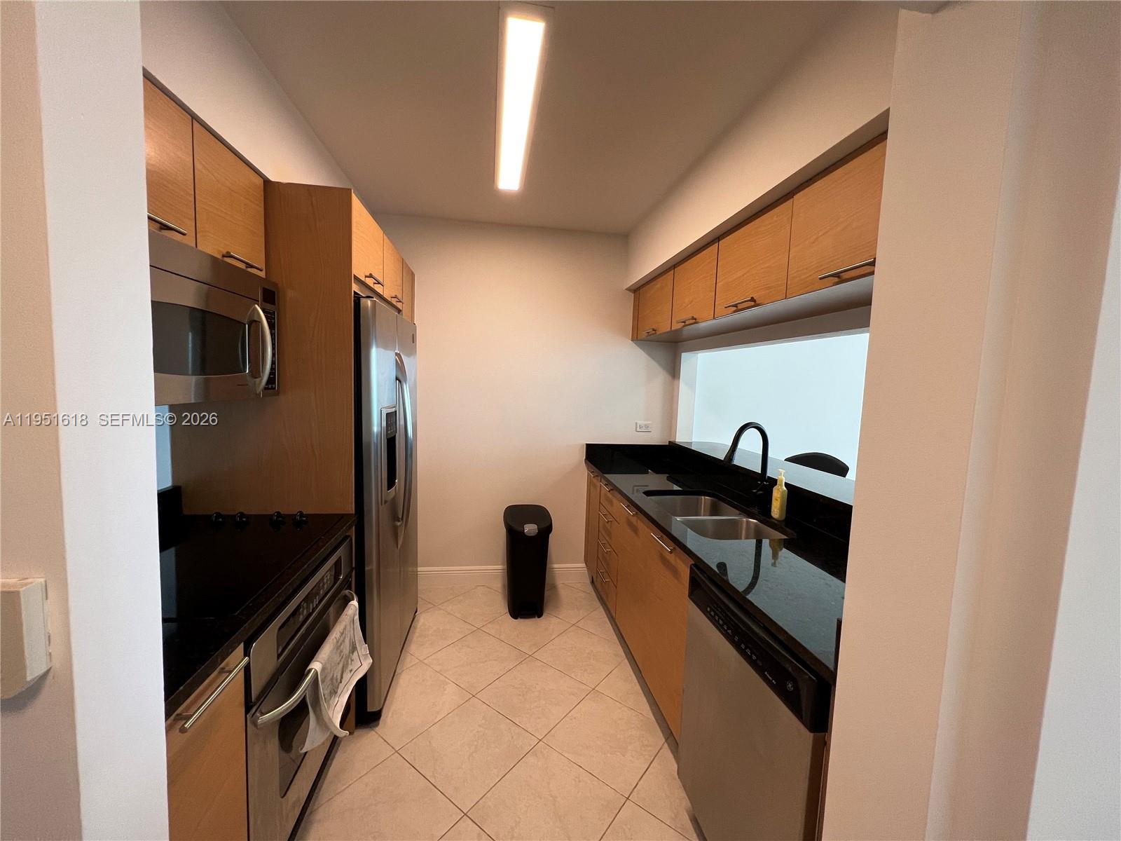 31 Southeast 5th Street, Unit 1409 Miami, FL 33131 - Photo 5 of 16 a kitchen with stainless steel appliances granite countertop a refrigerator and a stove