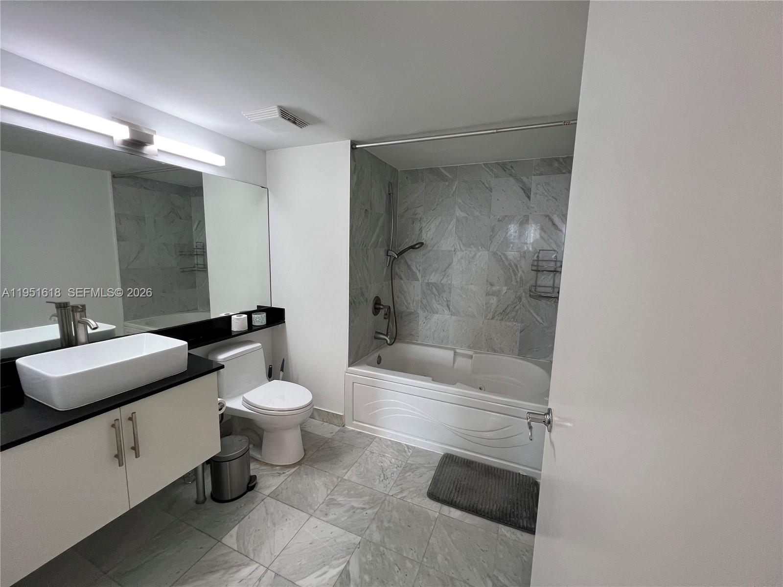 31 Southeast 5th Street, Unit 1409 Miami, FL 33131 - Photo 8 of 16 a bathroom with a sink a toilet and shower