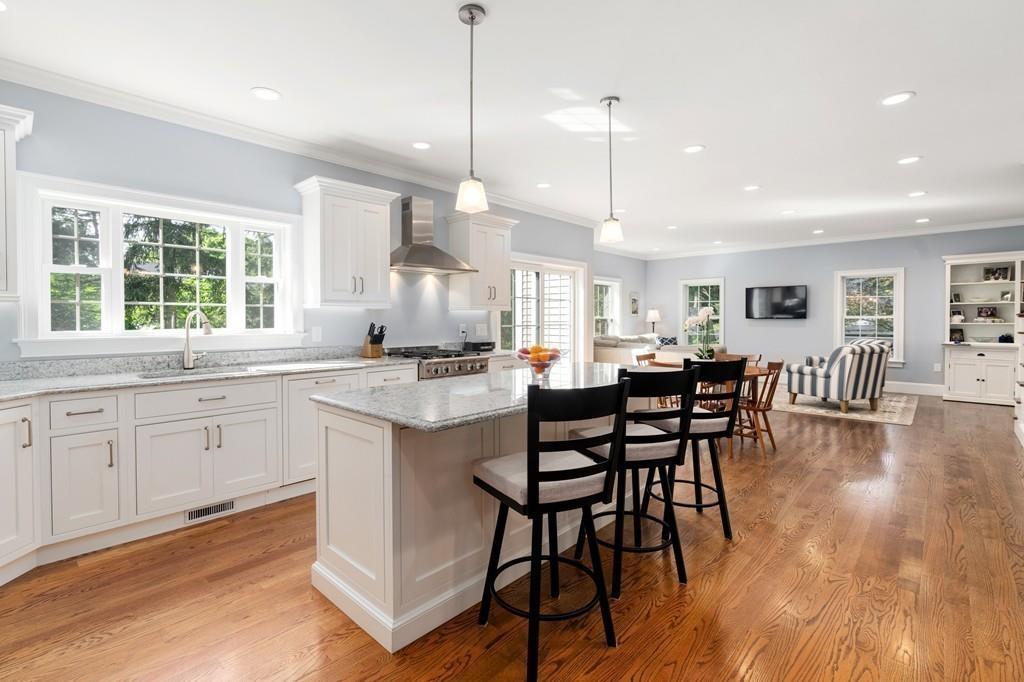 a kitchen with stainless steel appliances granite countertop wooden floor dining table and chairs