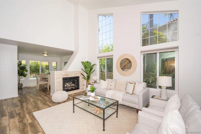 a living room with furniture a fireplace and a large window