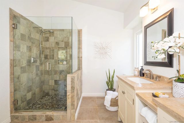a bathroom with a granite countertop sink a toilet and shower