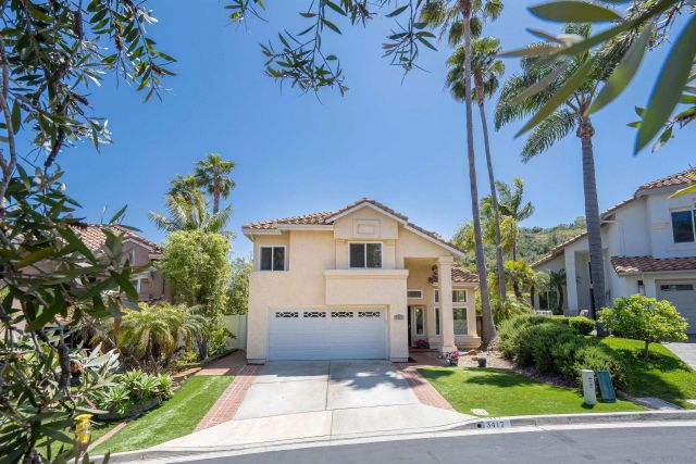 a white house with a yard and plants