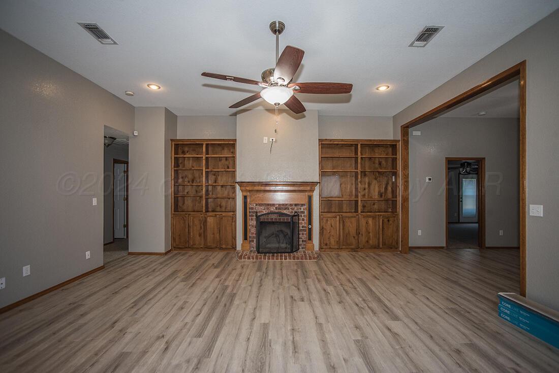 7909 Triumph Place Amarillo, TX 79119 - Photo 2 of 21 a view of a livingroom with a fireplace a ceiling fan and closet