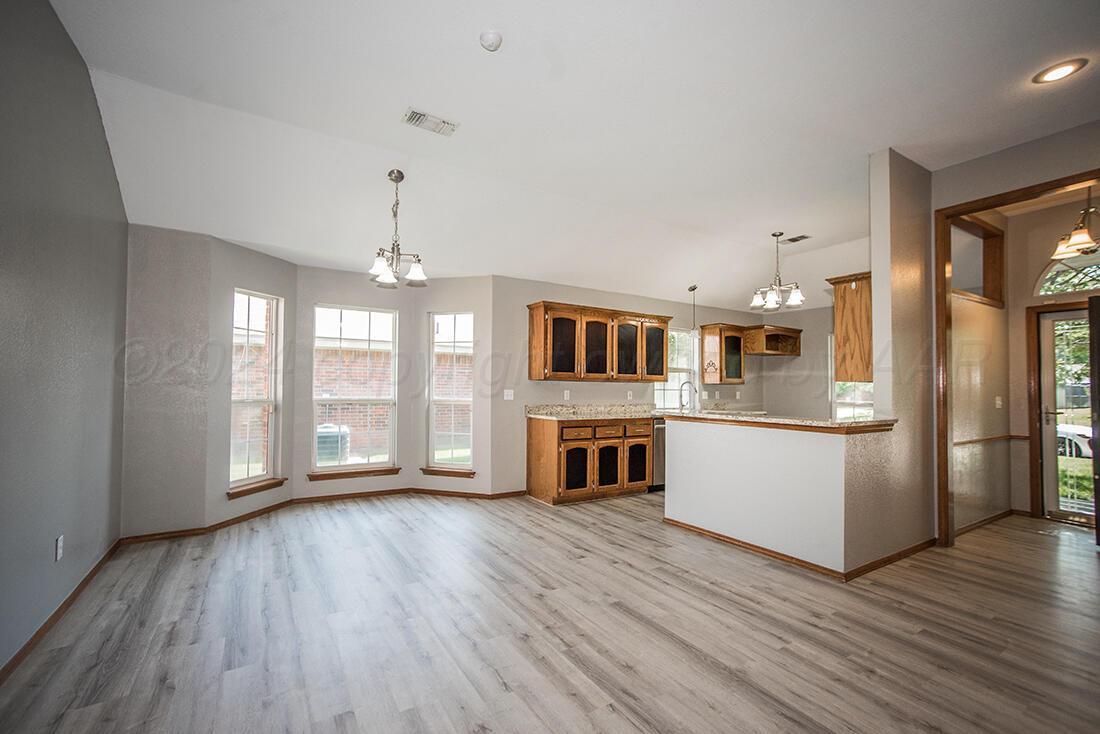 7909 Triumph Place Amarillo, TX 79119 - Photo 3 of 21 a living room with stainless steel appliances kitchen island hard wood floors and fireplace
