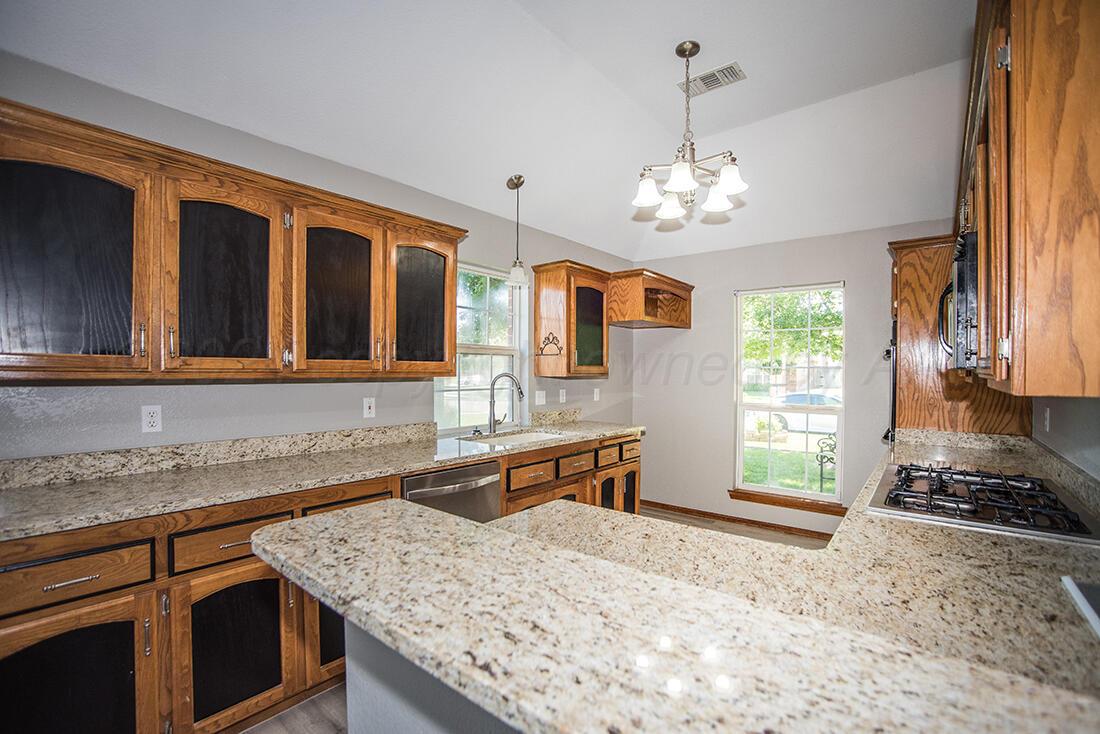 7909 Triumph Place Amarillo, TX 79119 - Photo 4 of 21 a kitchen with stainless steel appliances granite countertop a sink stove and cabinets