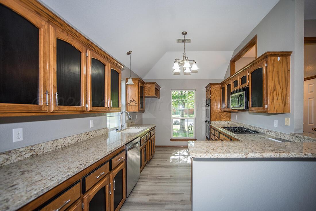 7909 Triumph Place Amarillo, TX 79119 - Photo 8 of 21 a kitchen with stainless steel appliances granite countertop a sink and a stove