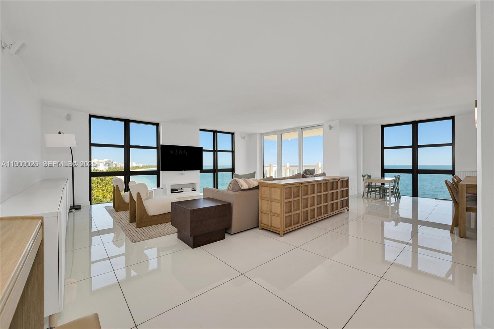 1111 Crandon Boulevard, Unit A801 Key Biscayne, FL 33149 - Photo 6 of 29 a living room with furniture a flat screen tv and a floor to ceiling window