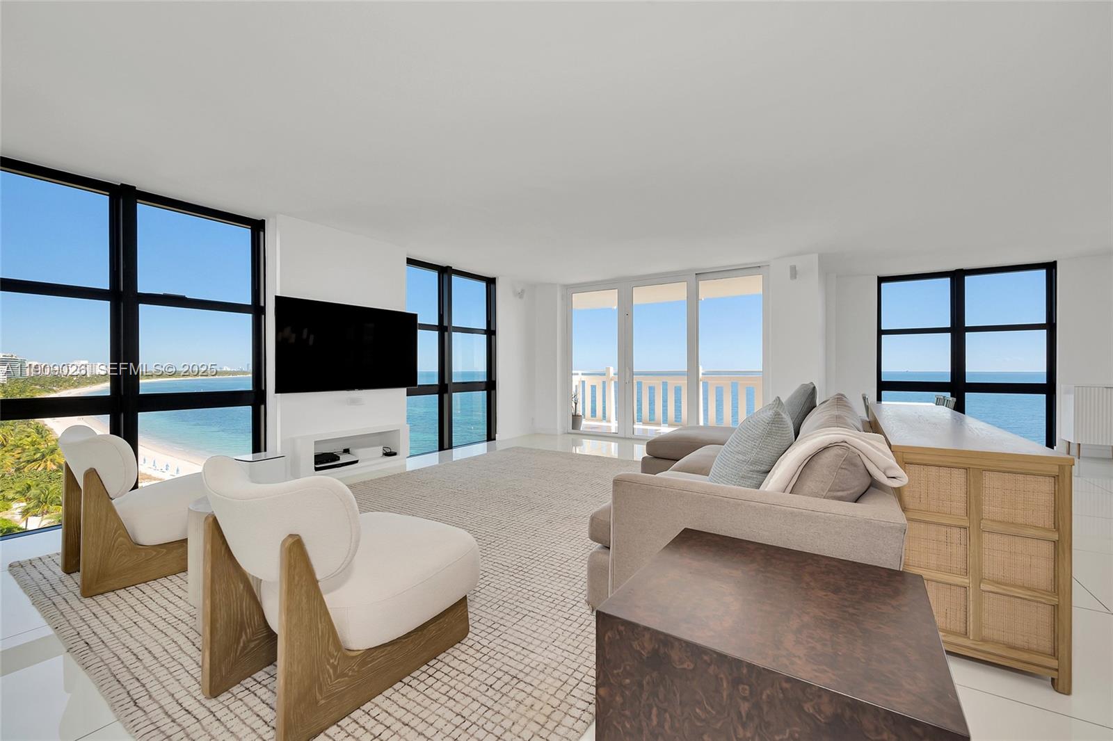 1111 Crandon Boulevard, Unit A801 Key Biscayne, FL 33149 - Photo 7 of 29 a living room with furniture a flat screen tv and a floor to ceiling window