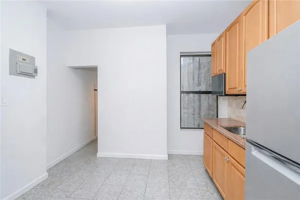 a kitchen with granite countertop white cabinets and refrigerator