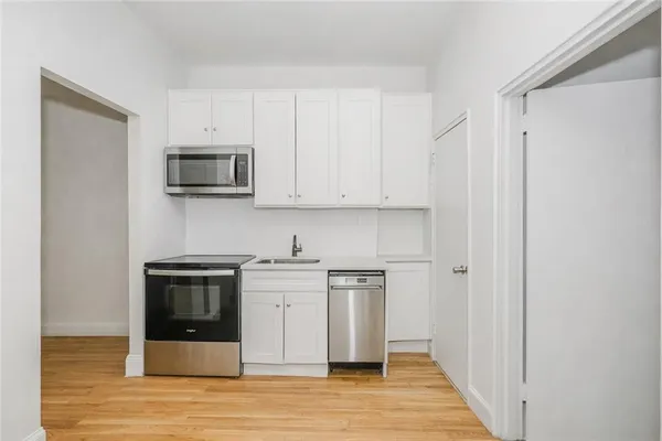 a kitchen with stainless steel appliances a stove a microwave and sink