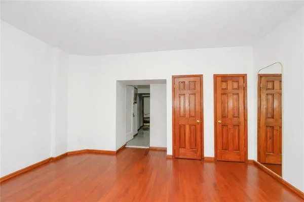 an empty room with wooden floor and closet