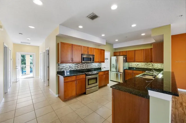 a kitchen with stainless steel appliances granite countertop a stove and a refrigerator