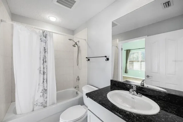 a bathroom with a granite countertop sink toilet bathtub and shower