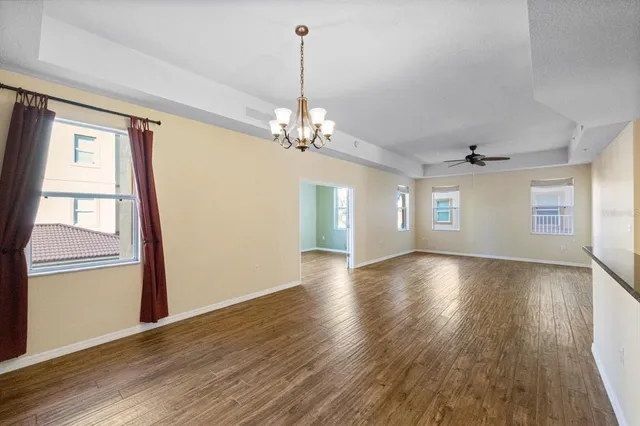 a view of a livingroom with wooden floor and a ceiling fan
