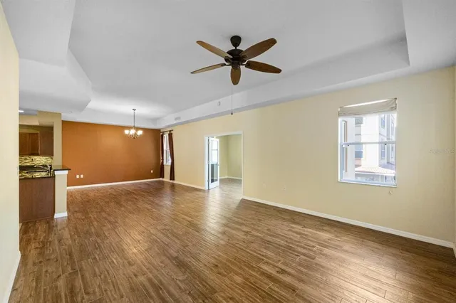 a view of empty room with wooden floor and fan