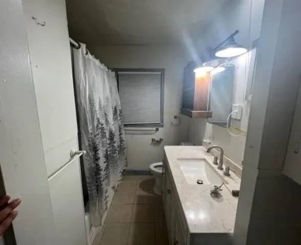 a bathroom with a sink and mirror with toilet