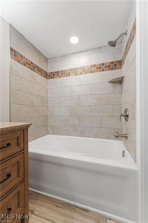 3793 Ranfield Road Kent, OH 44240 - Photo 14 of 40 Full bathroom featuring bathing tub / shower combination, light wood-style floors, a textured ceiling, and vanity