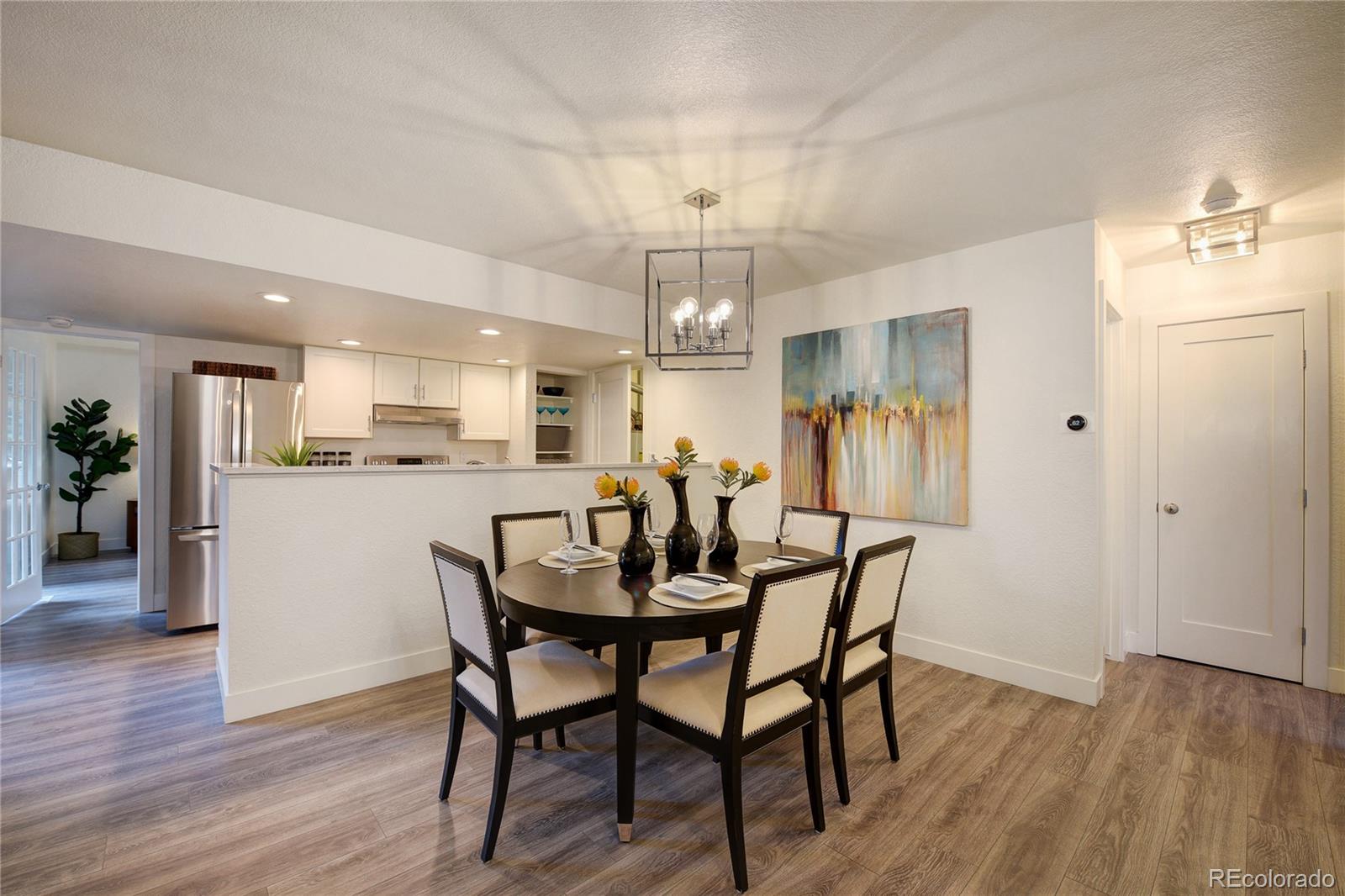 a view of a dining room and livingroom with furniture wooden floor a chandelier