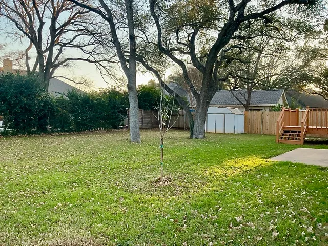 a view of a house with backyard and trees