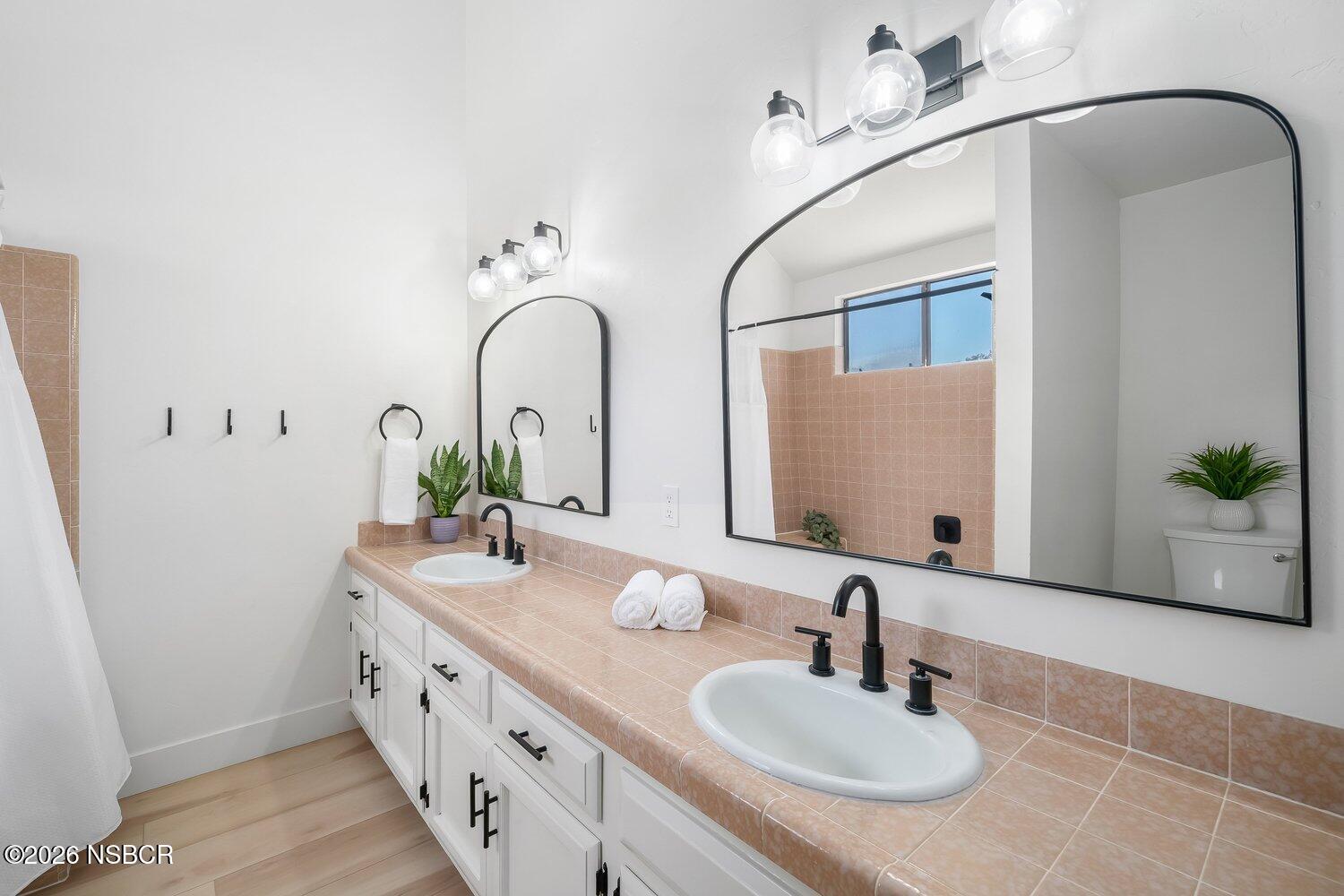 1496 Oakridge Park Road Santa Maria, CA 93455 - Photo 28 of 62 a bathroom with double vanity sinks a vanity and a mirror