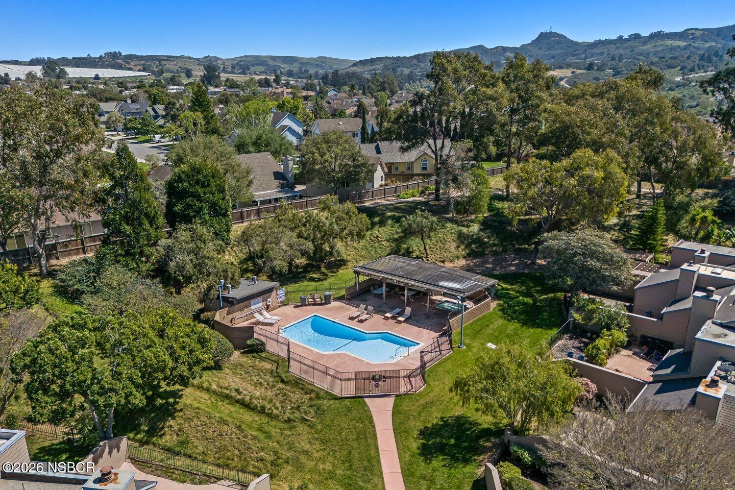 1496 Oakridge Park Road Santa Maria, CA 93455 - Photo 61 of 62 a view of a swimming pool with a table and chairs under an umbrella