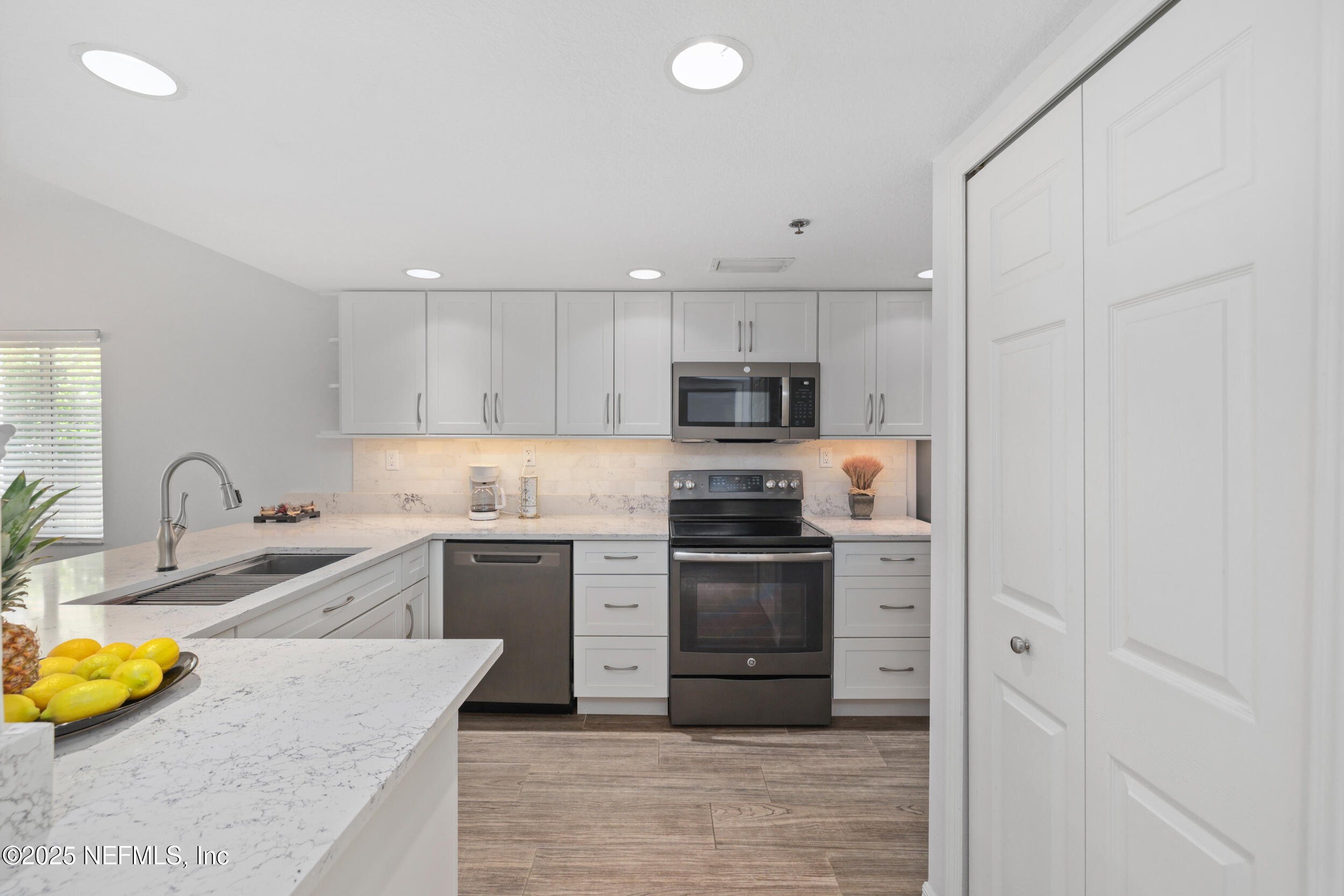 a kitchen with stainless steel appliances granite countertop a sink stove and refrigerator