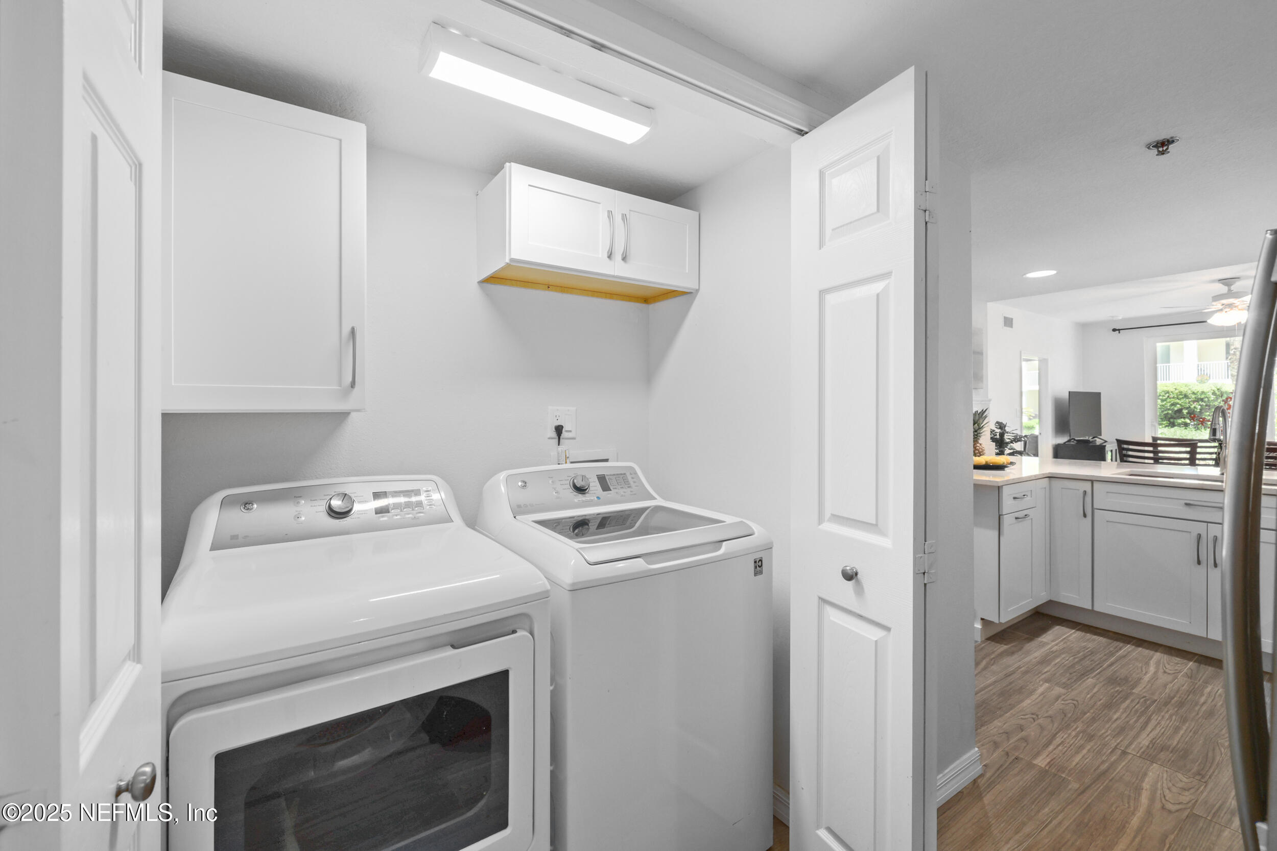 159 Marine Street, Unit 105 St. Augustine, FL 32084 - Photo 15 of 46 a view of washer and dryer with kitchen in the background