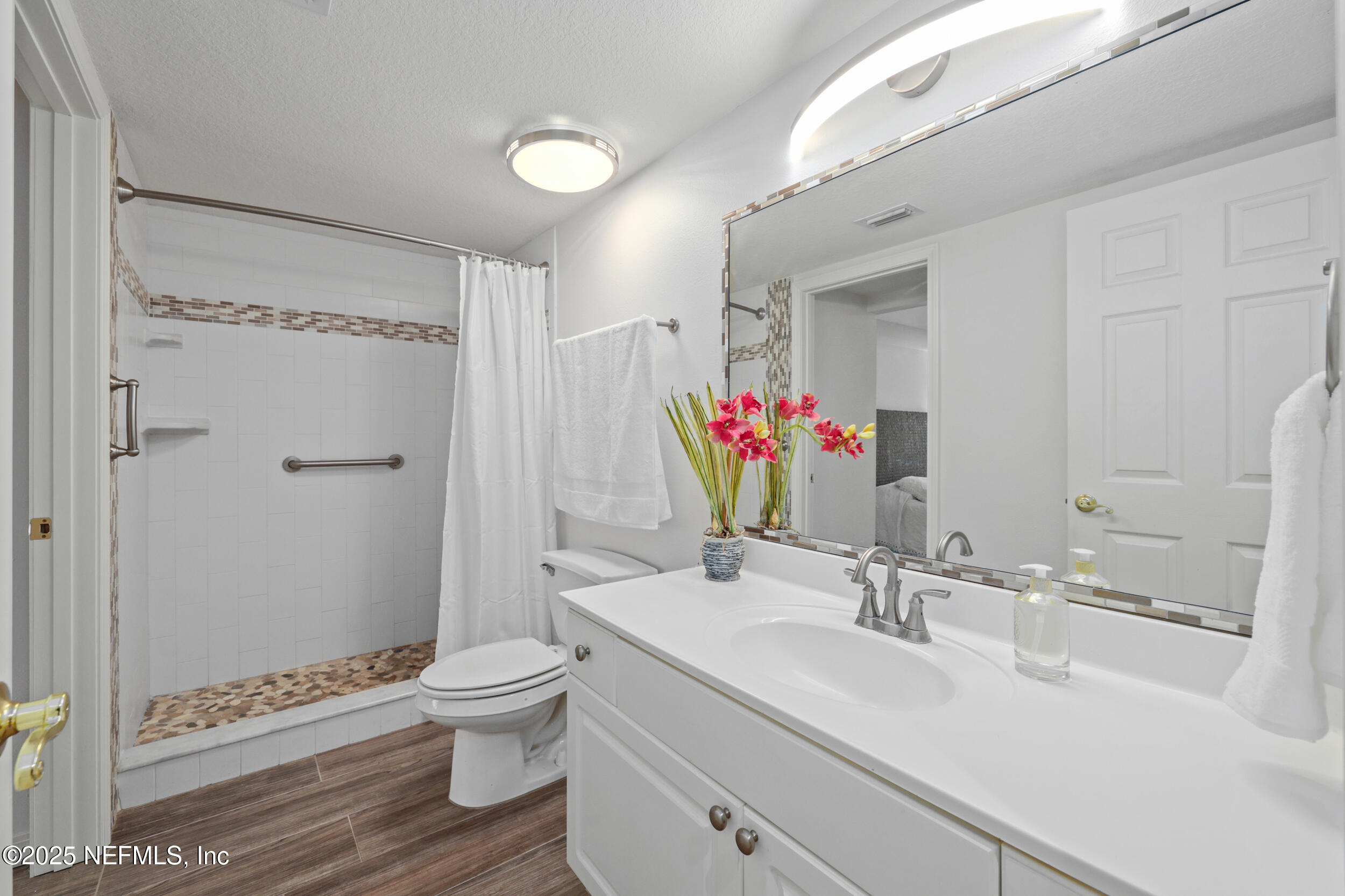 159 Marine Street, Unit 105 St. Augustine, FL 32084 - Photo 28 of 46 a bathroom with a sink toilet a mirror and shower