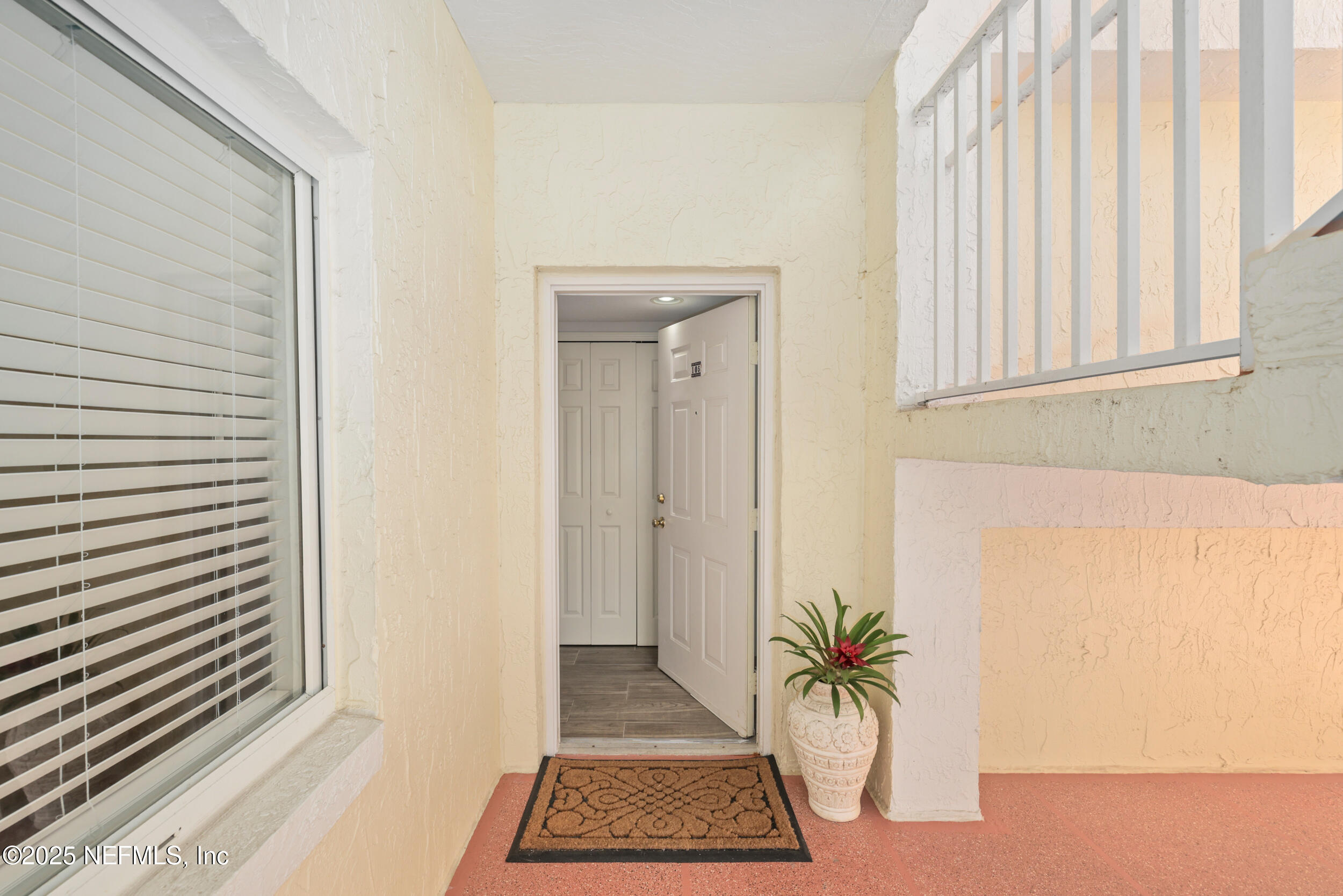 159 Marine Street, Unit 105 St. Augustine, FL 32084 - Photo 6 of 46 a view of a hallway with wooden floor and a potted plant