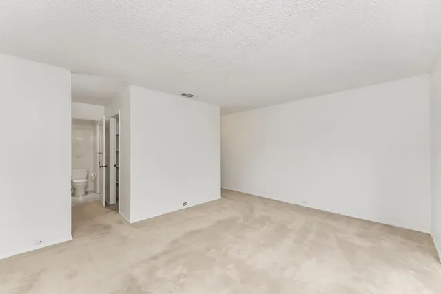 an empty room with sliding glass door and shower