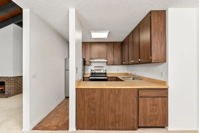 a kitchen with a stove a microwave and wooden cabinets