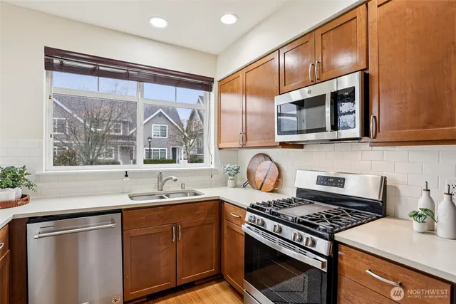 a kitchen with stainless steel appliances a stove sink and microwave