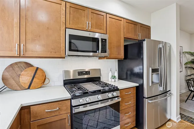 a kitchen with stainless steel appliances granite countertop a stove microwave and refrigerator