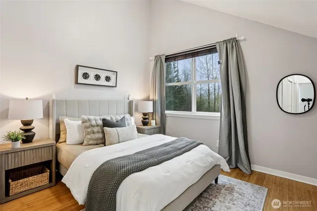 a bedroom with a bed a mirror and a window