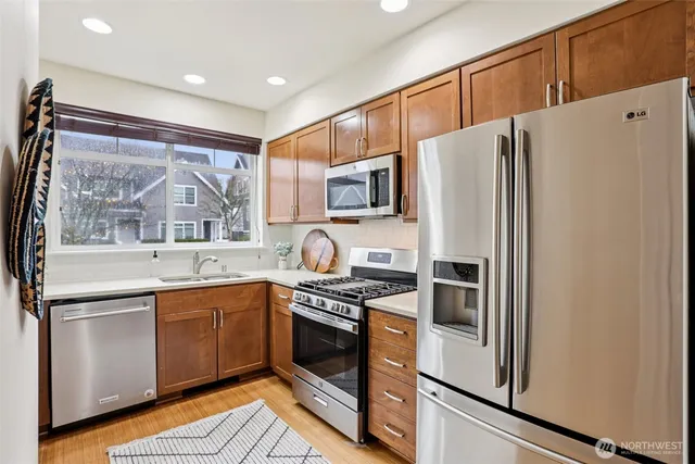 a kitchen with stainless steel appliances a refrigerator sink and microwave