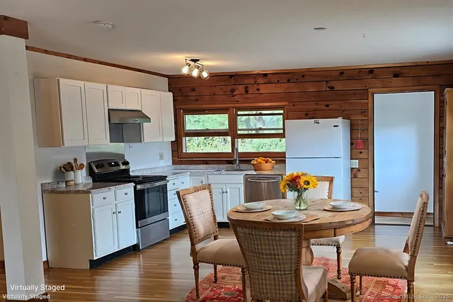 a kitchen with a stove a table and chairs in it