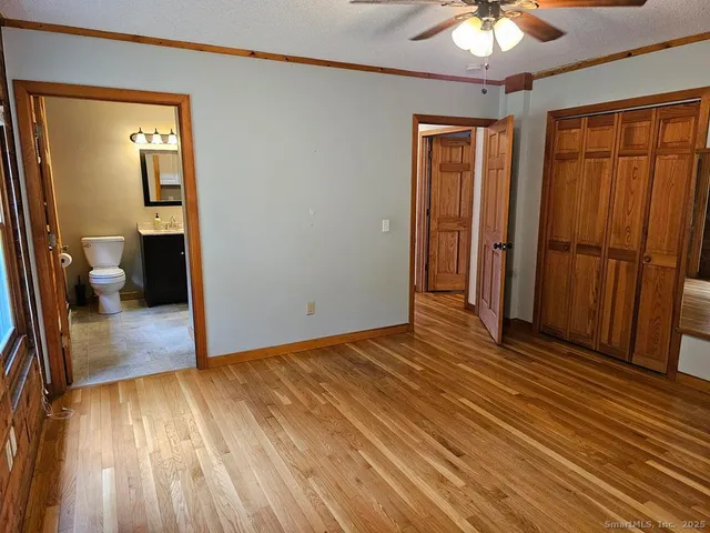 a view of a room with wooden floor and a ceiling fan