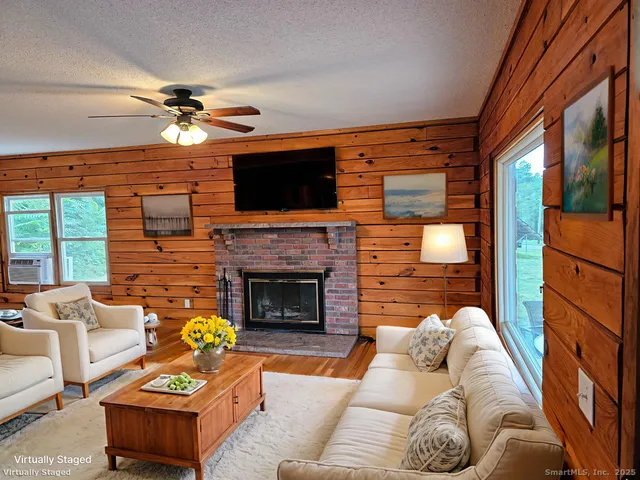 a living room with furniture a fireplace and a flat screen tv