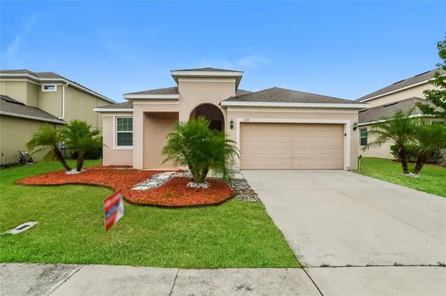 a front view of a house with a yard and garage