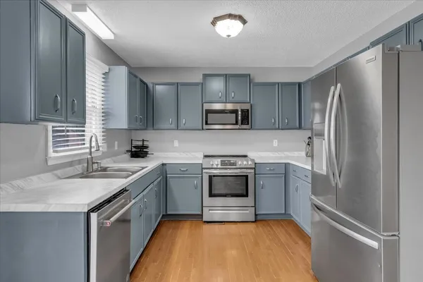 a kitchen with a sink stove and refrigerator