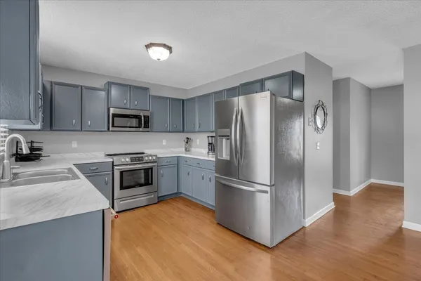 a kitchen with granite countertop a refrigerator stove and sink