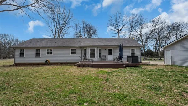 a view of a house with backyard and sitting area