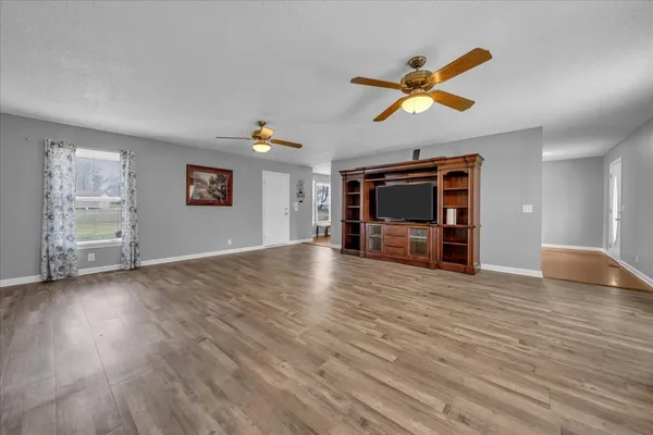 a view of empty room with wooden floor