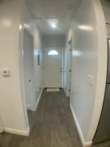 a view of a hallway with wooden floor