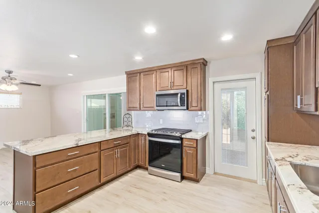 a large kitchen with stainless steel appliances granite countertop a stove and a sink
