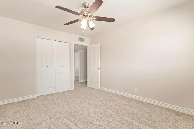 an empty room with a ceiling fan and a window