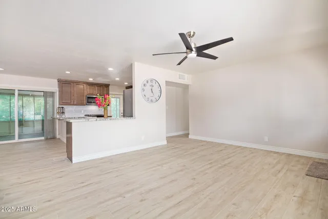 a view of a kitchen with wooden floor and white cabinets